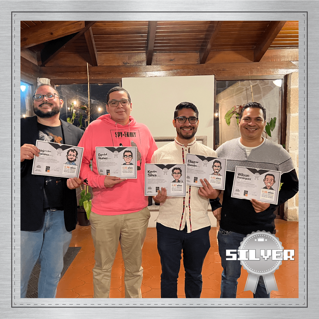 Fotografía grupal de los galardonados con el Premio Silver en Andes Development, reconociendo de 4 a 5 años de trayectoria en la agencia. El equipo técnico y directivo posa sonriente mostrando sus diplomas con avatares en pixel art durante la celebración del 12º aniversario.